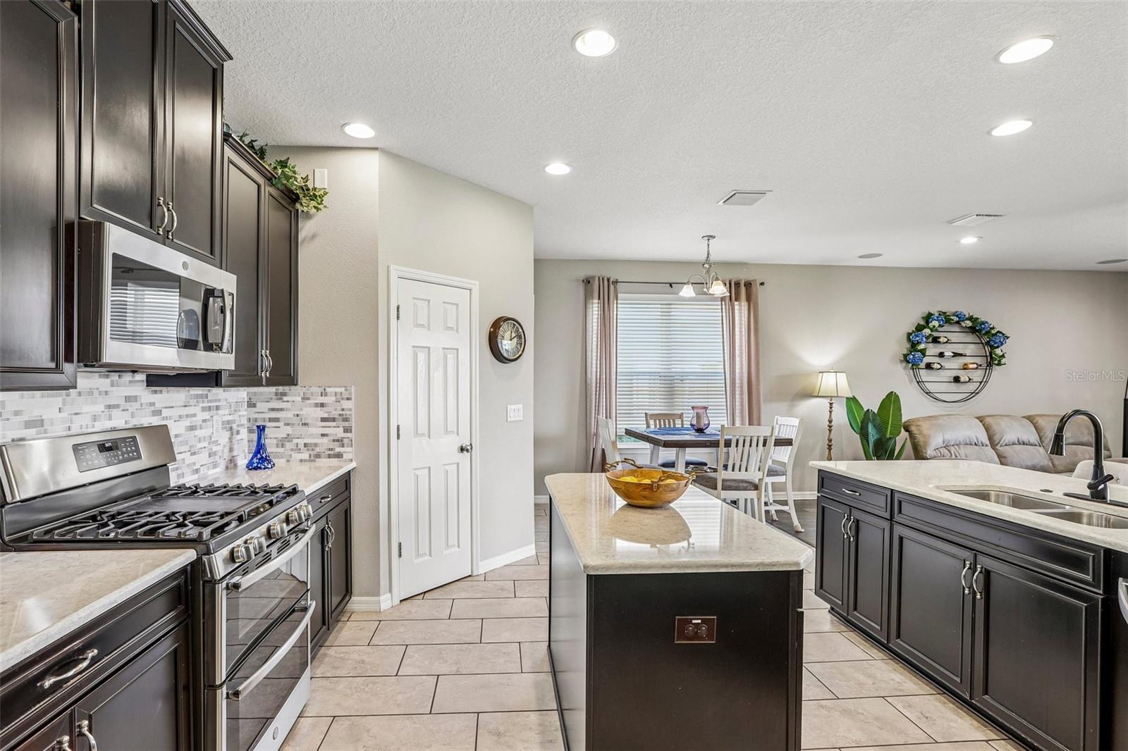 Kitchen area with 42" cabinets, stained appliances, gas range, beautiful backsplash, Island and quartz