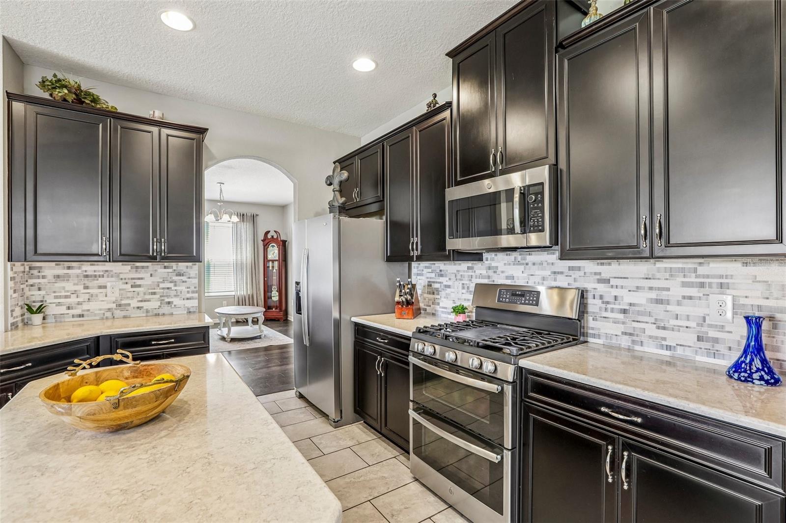 Kitchen area with 42" cabinets, stained appliances, gas range, beautiful backsplash, Island and quartz