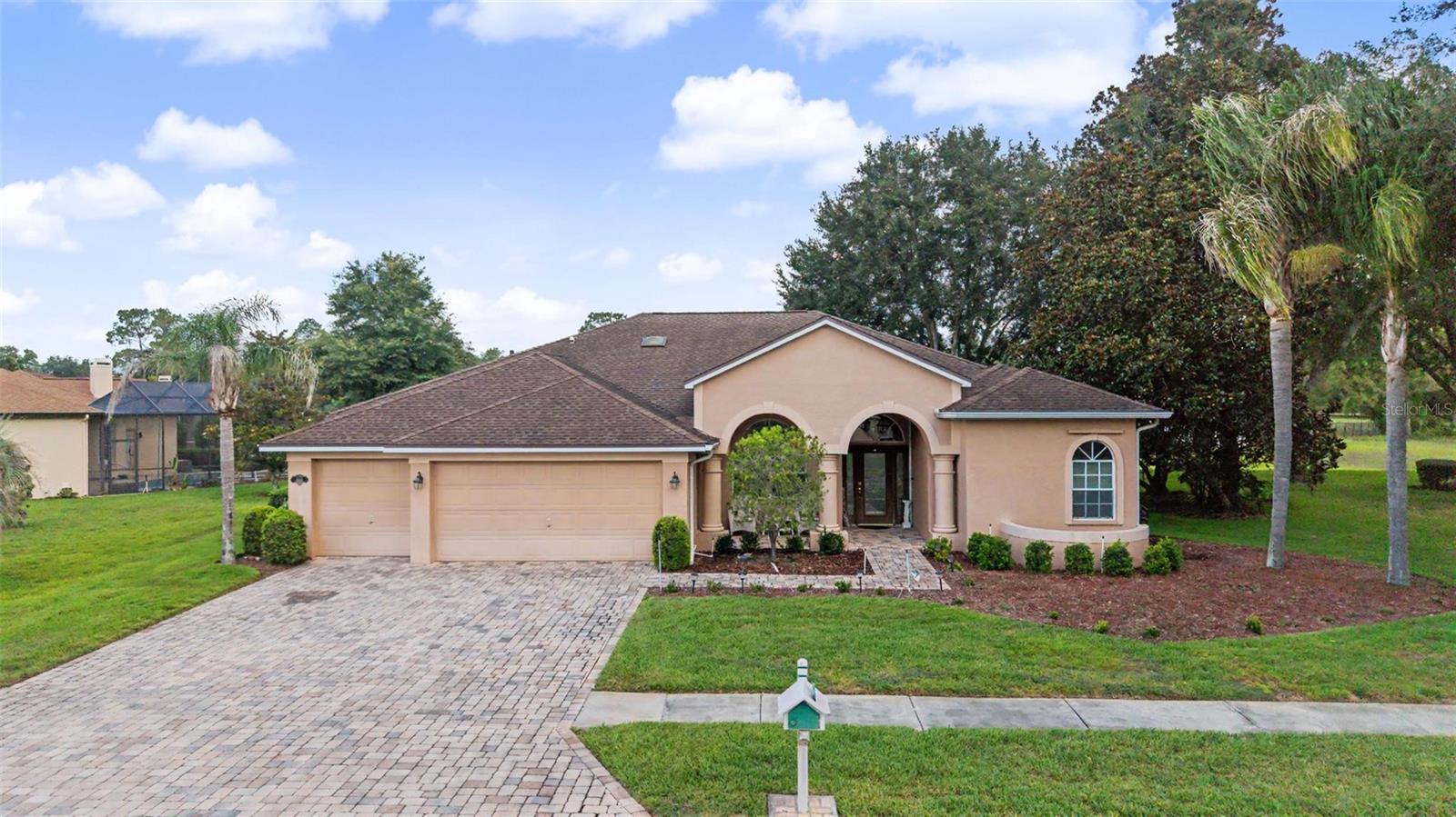 Welcome home to this beautifully maintained residence in Silverthorn Golf & Country Club. The inviting curb appeal features lush tropical landscaping, mature palm trees, a paver driveway, and a spacious three-car garage, creating a stunning first impression from the moment you arrive.