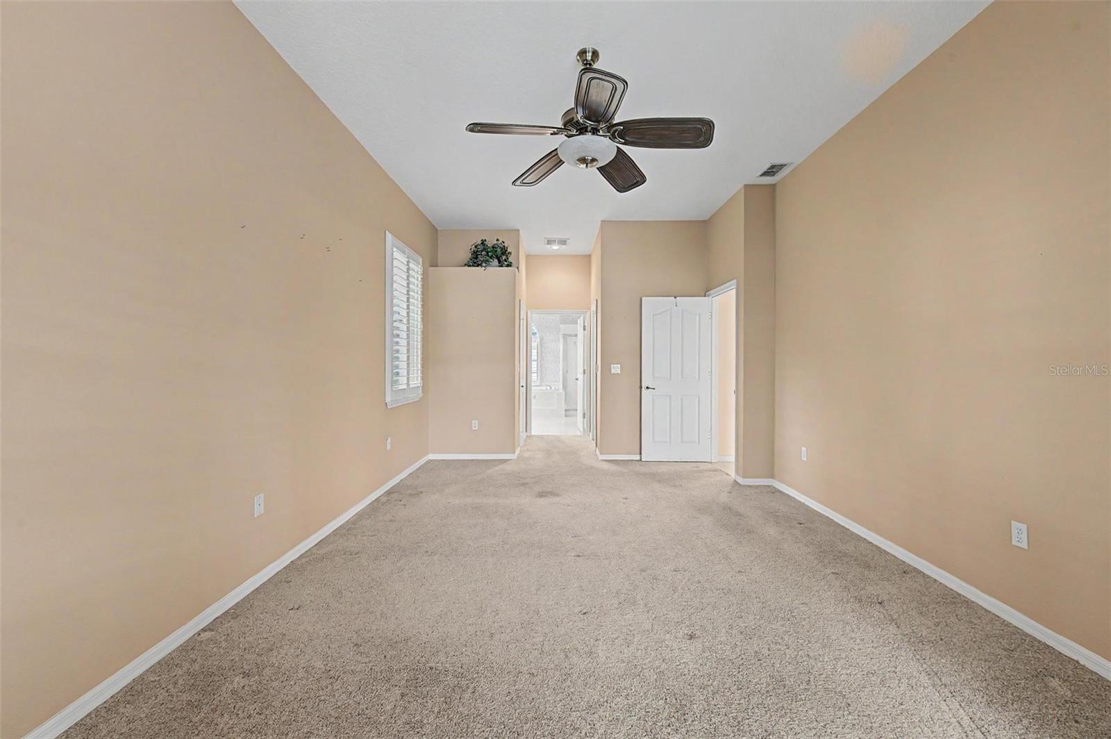 Spacious primary suite featuring a generous layout with room for a sitting area and two separate closets, providing exceptional storage and organization. Large windows fill the room with natural light, creating a bright and inviting retreat.