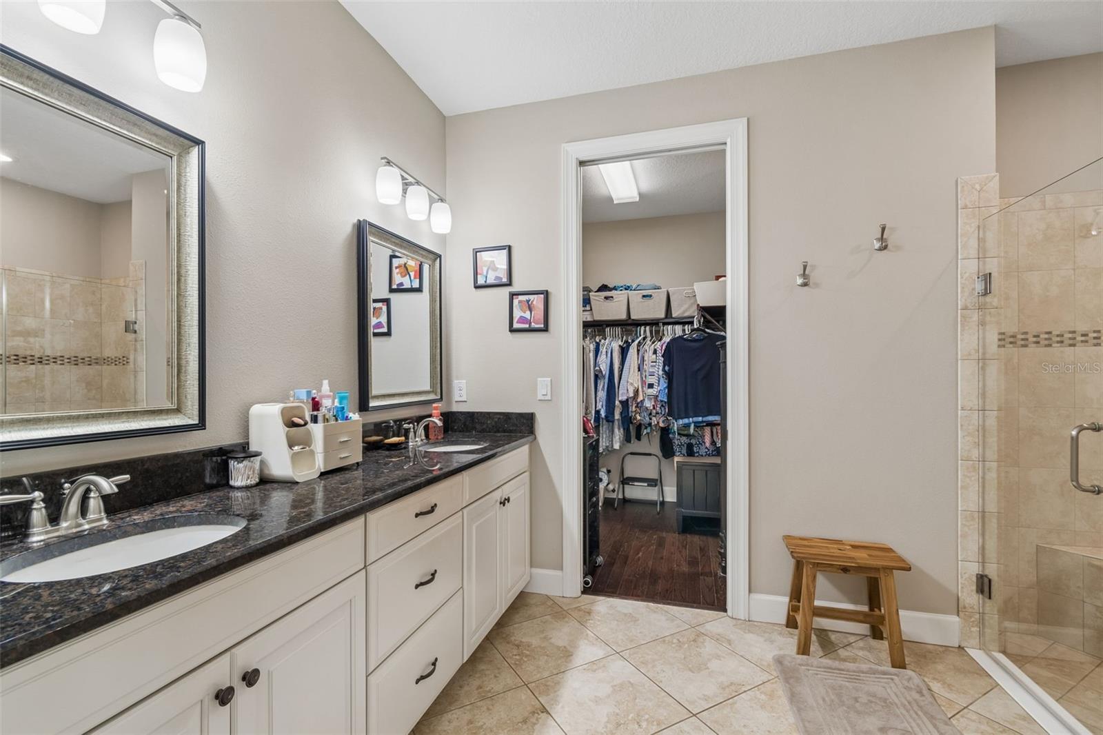 Primary ensuite, dual sinks, glass enclosed shower with bench and large walk-in closet