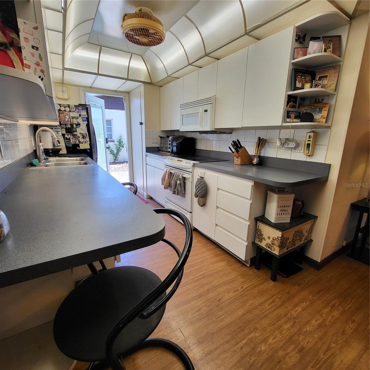 Galley style kitchen offers plenty of counter & storage space.  Notice convenient side door entry from parking pad.
