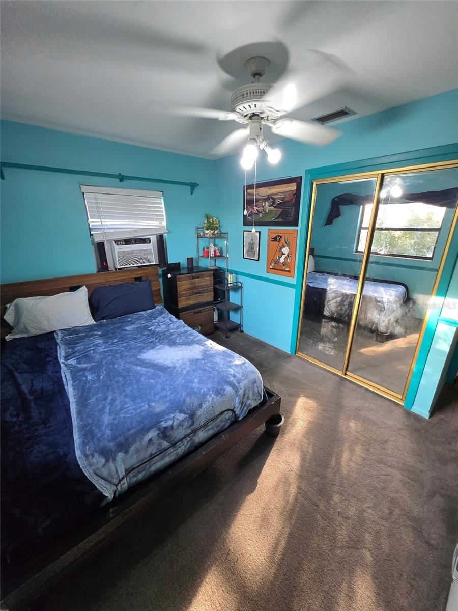 Bedroom two has mirrored closet doors & a ceiling fan.