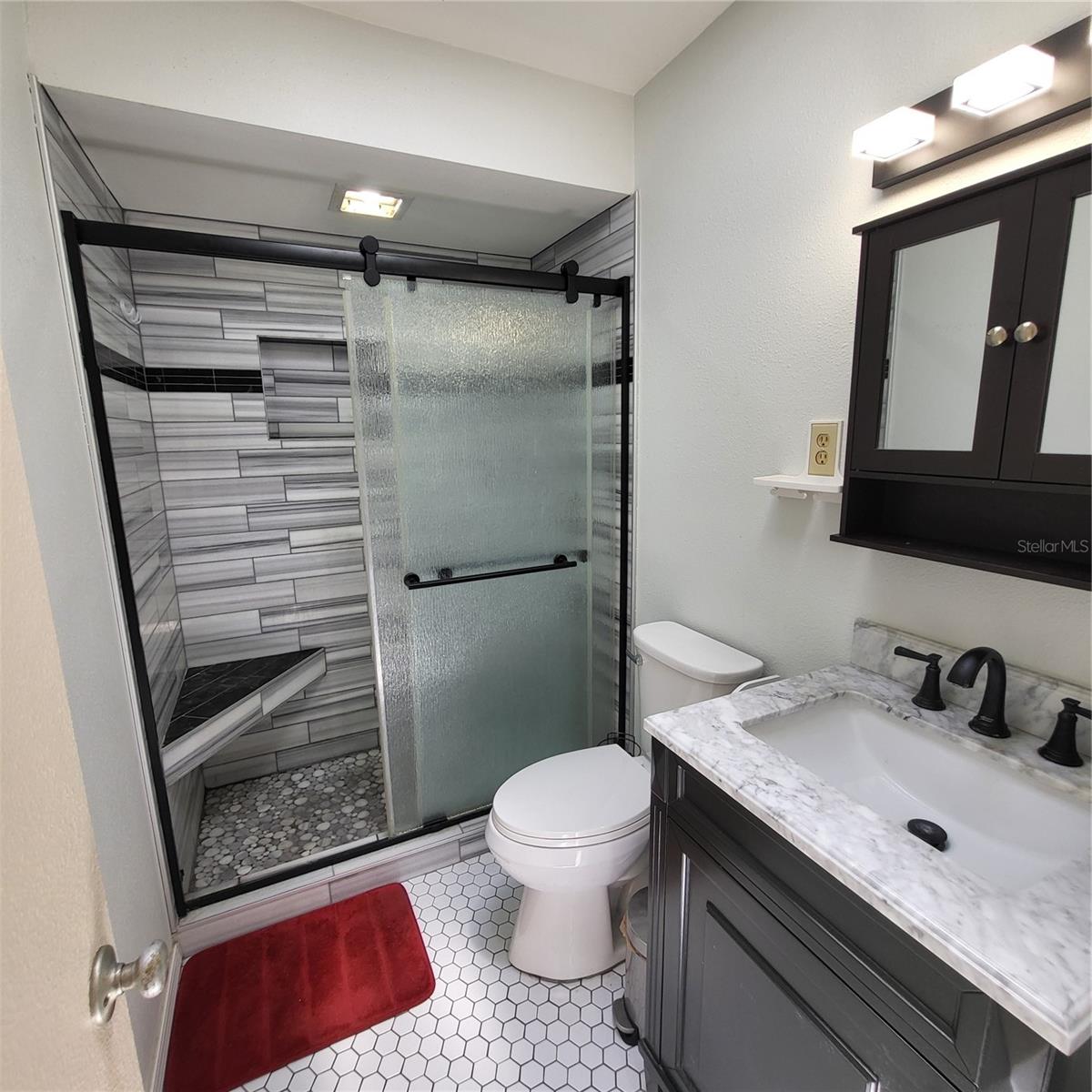 Primary bath offers walk in shower with sliding doors