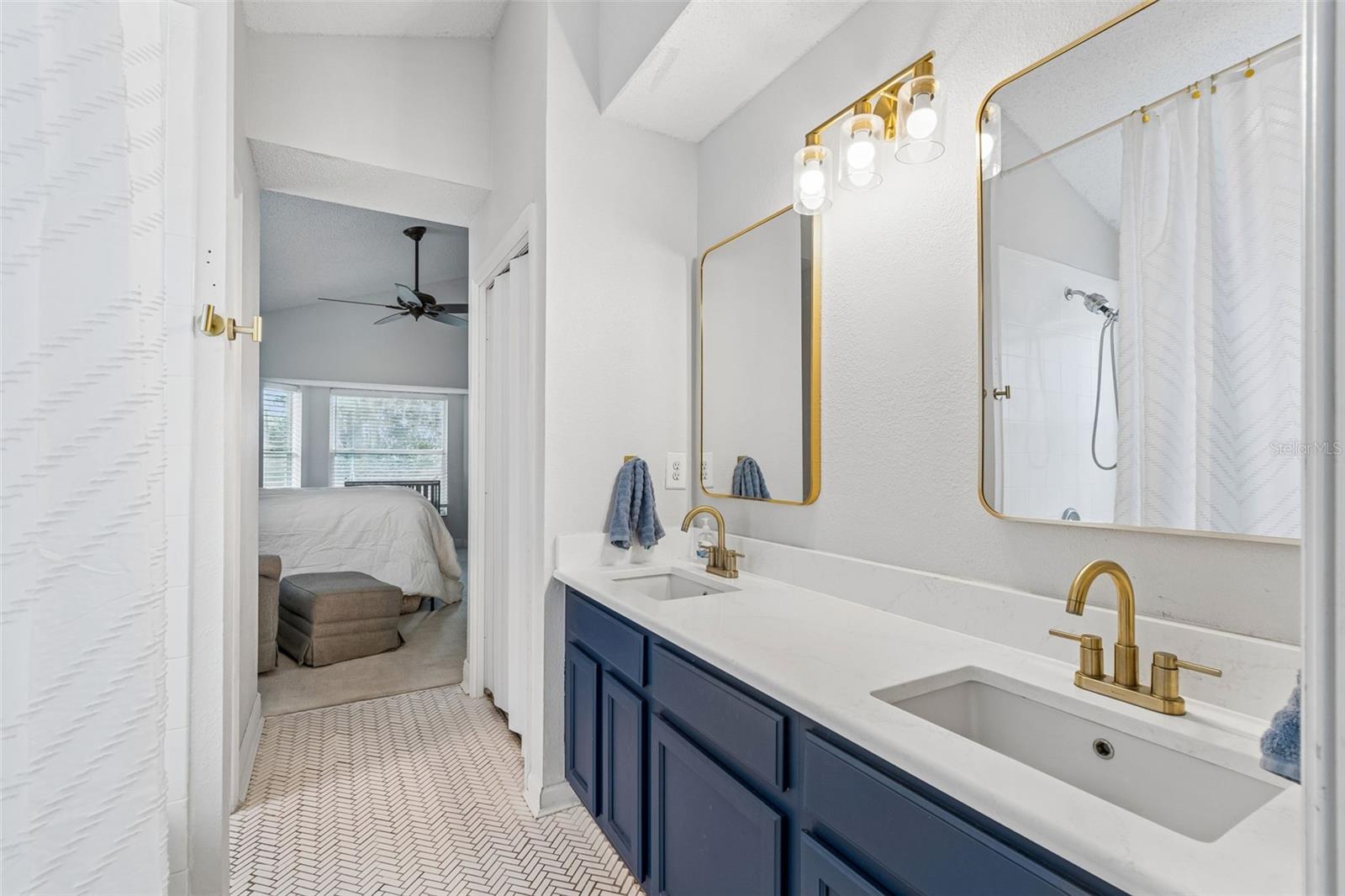 Primary bath with quartz counters and herringbone tilework