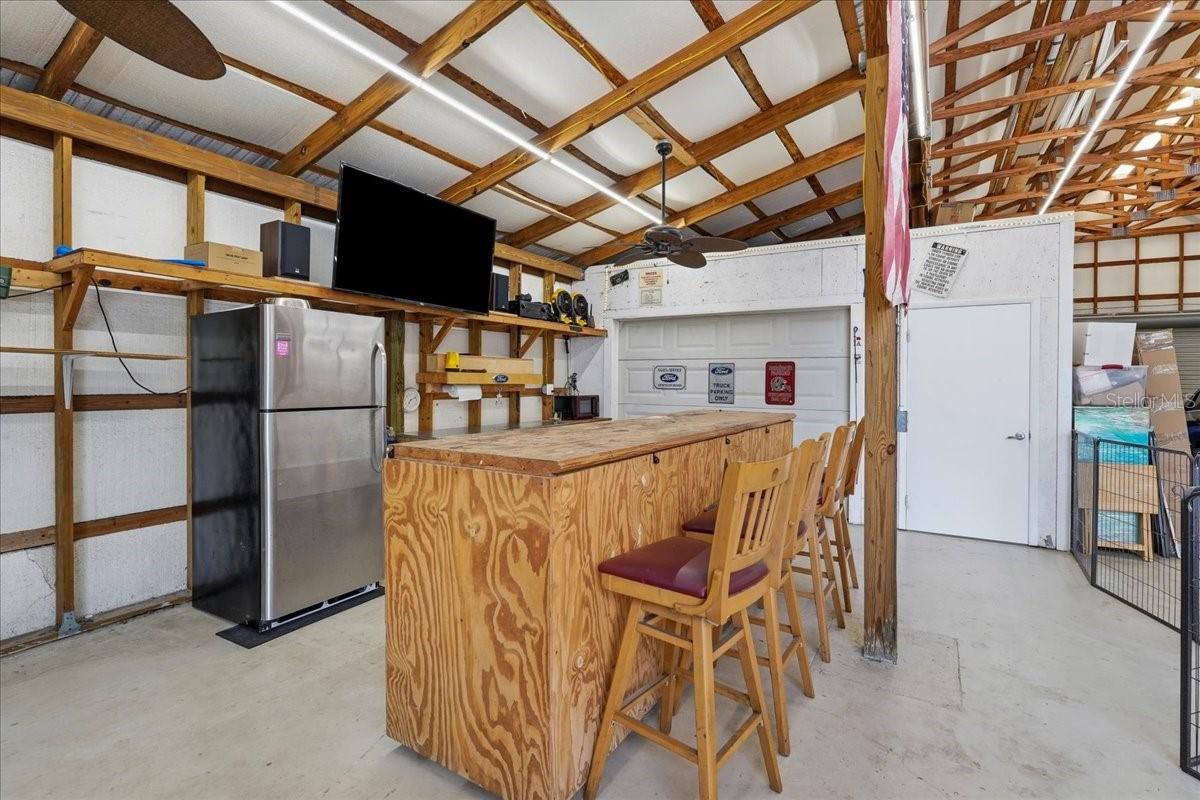 Bar area has fridge, sink, ceiling fans.