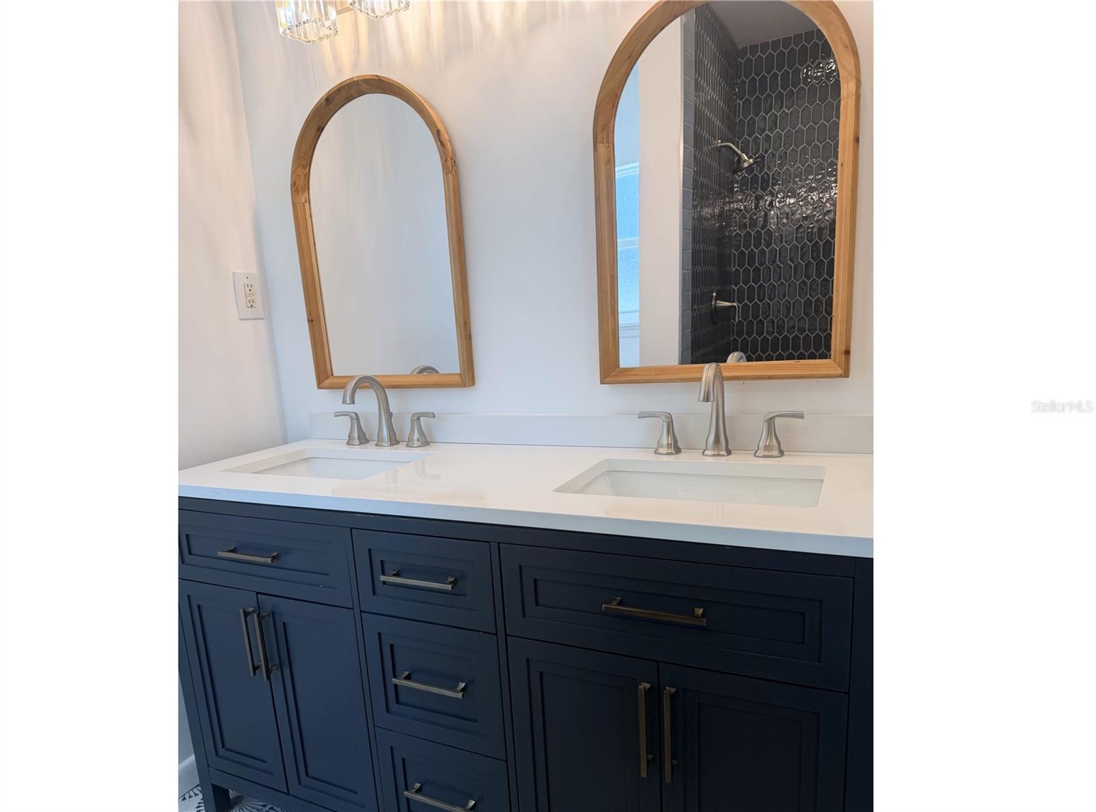 Primary bathroom features a large dual-sink vanity with sleek, spacious cabinetry for exceptional storage.