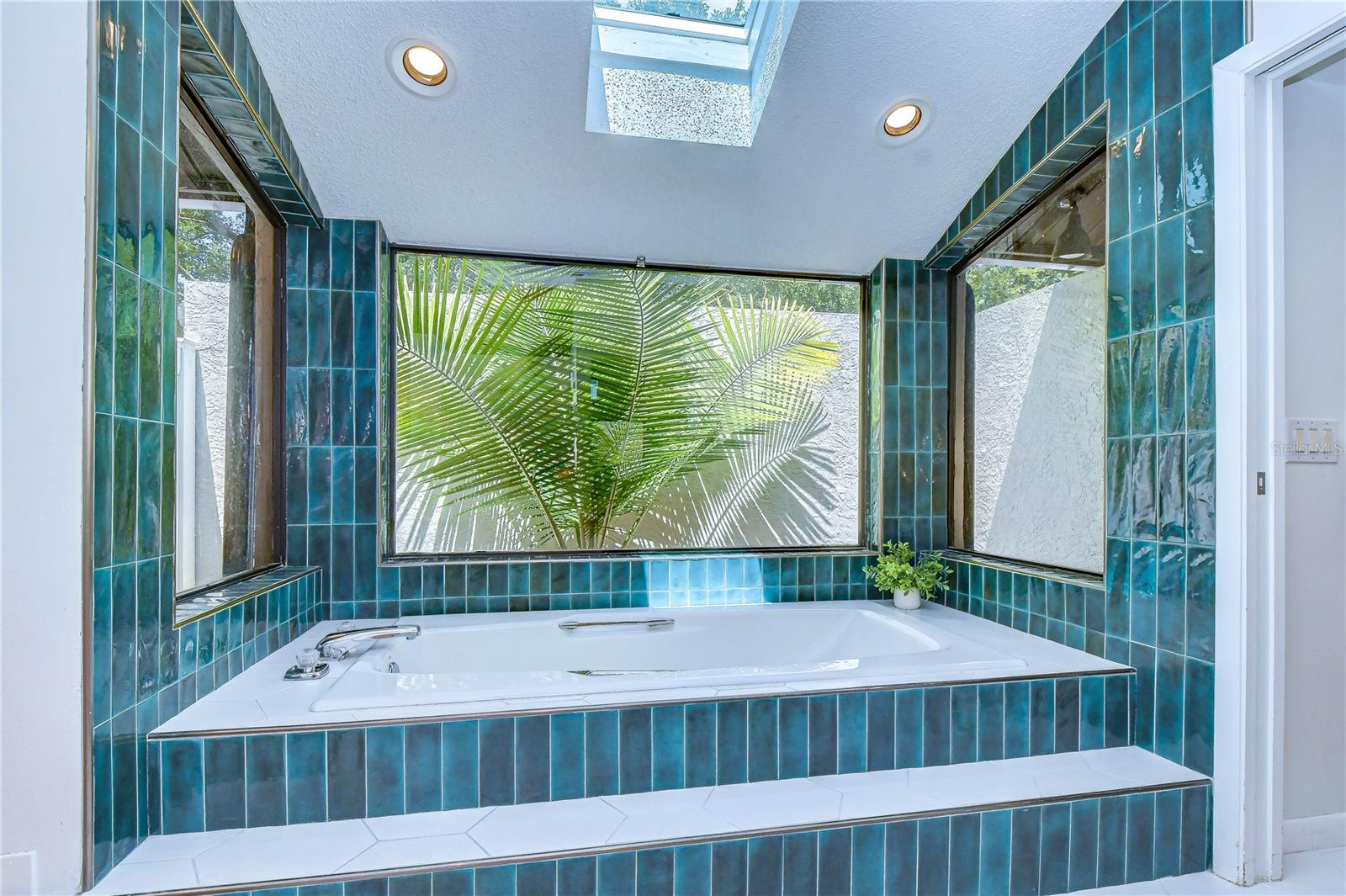 Relaxing garden tub overlooking a private courtyard.