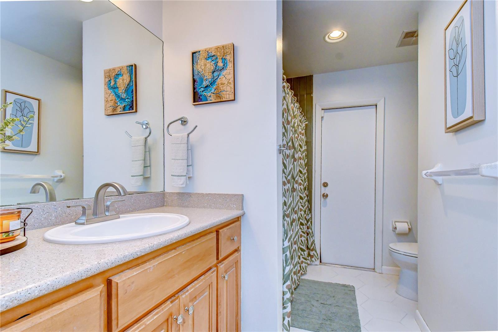 Updated full bathroom with refreshed tile flooring and shower surround.