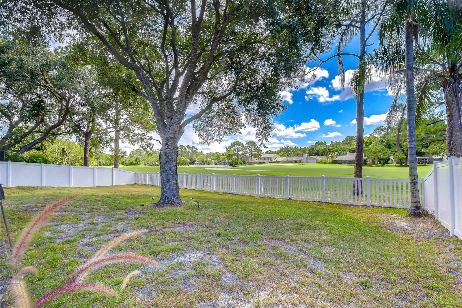 White vinyl fencing providing privacy while preserving open golf course vistas.