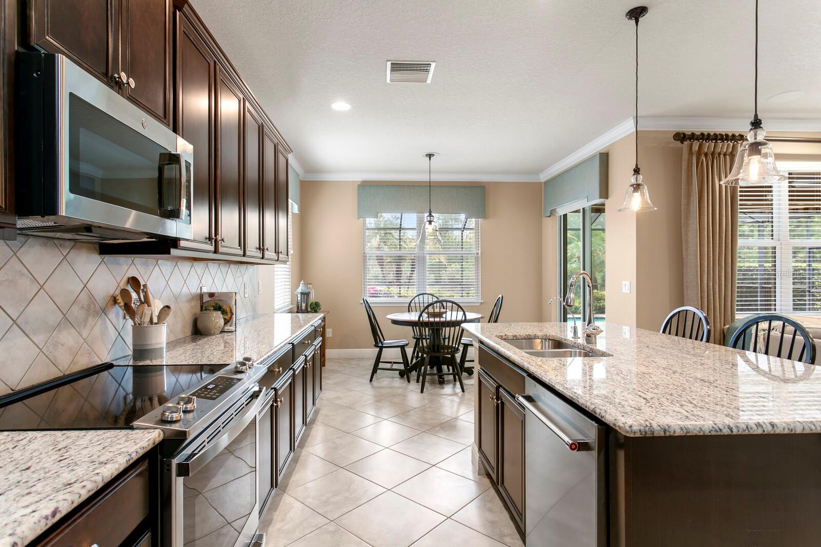 Stainless appliances, tiled backsplash & pendant lighting