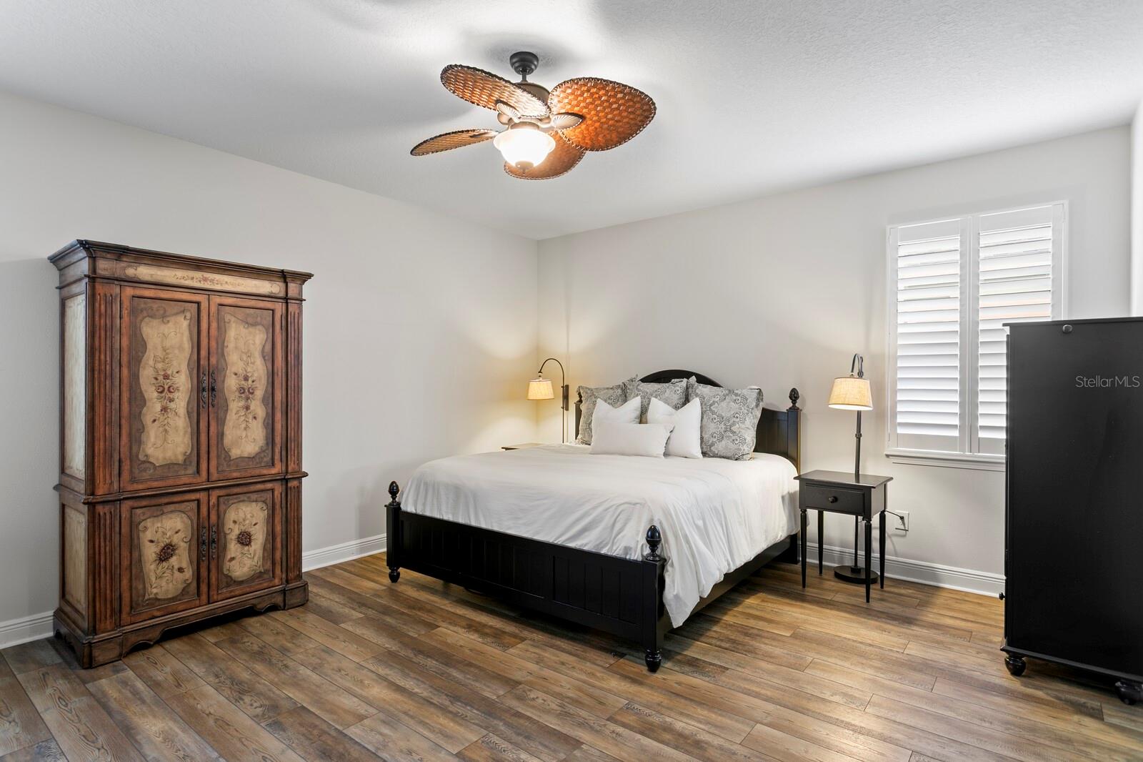 Ceiling fan, newer LVP floors and plantation shutters in the primary suite