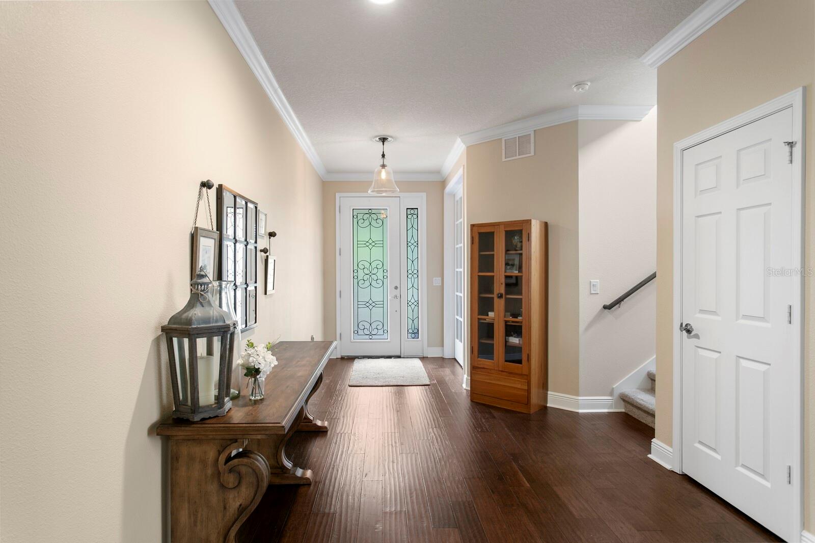 Large foyer entry with custom front door & hand-scraped hardwood floors in main living areas