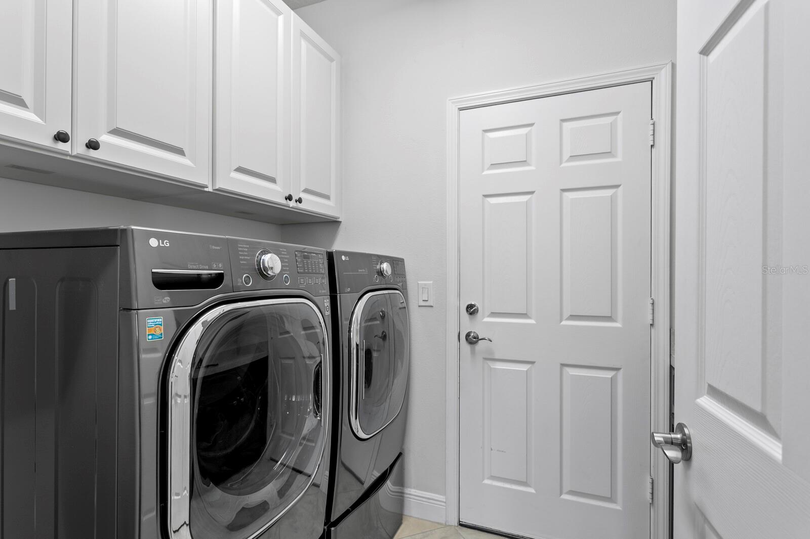 1st floor laundry room with utility sink, cabinet storage and access to 3-car garage
