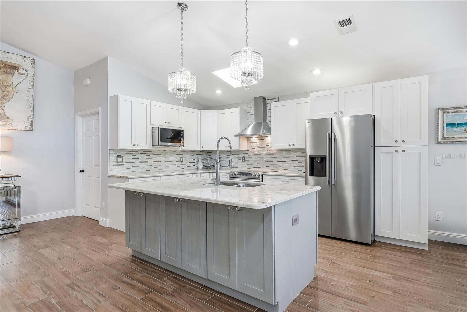 The kitchen island features additional storage and a breakfast bar.