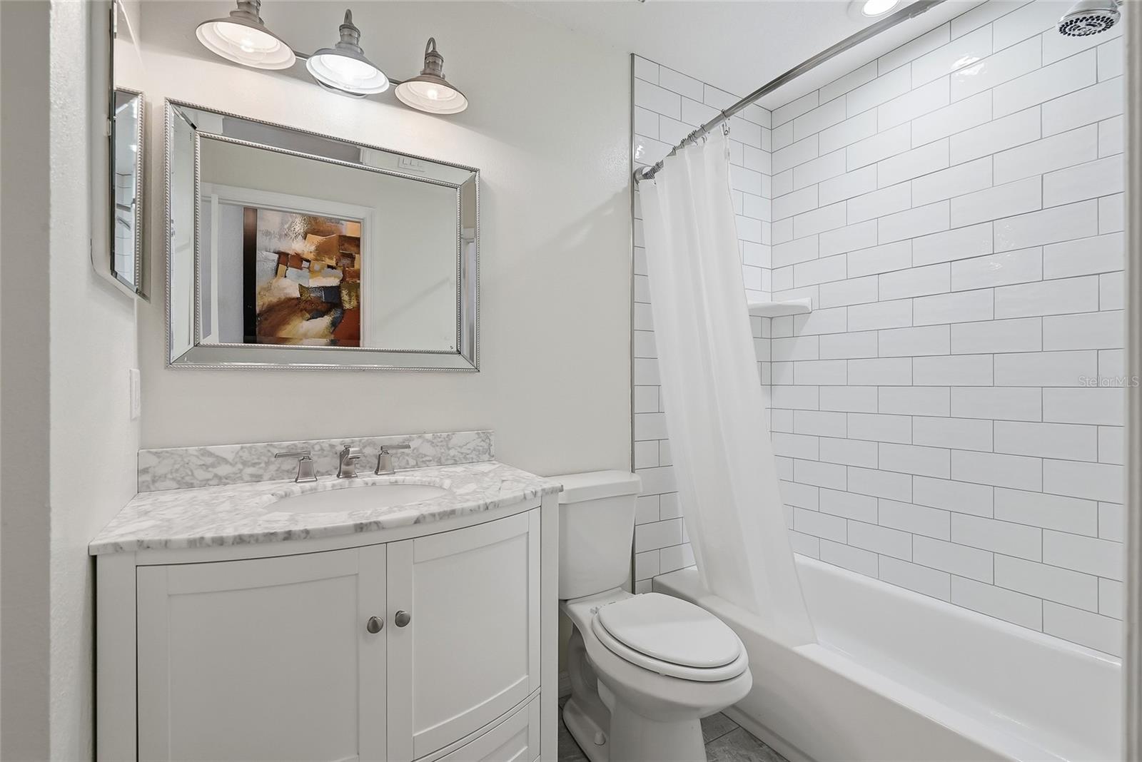 Renovated hallway bath with a tub/shower.