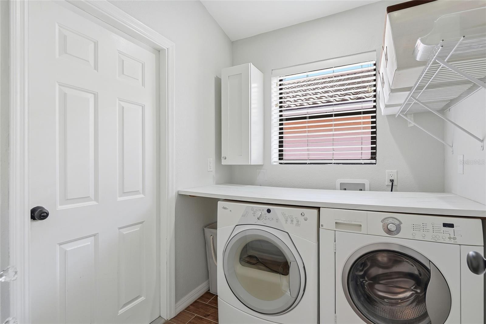 Interior laundry room with a folding counter provides comfort and ease.