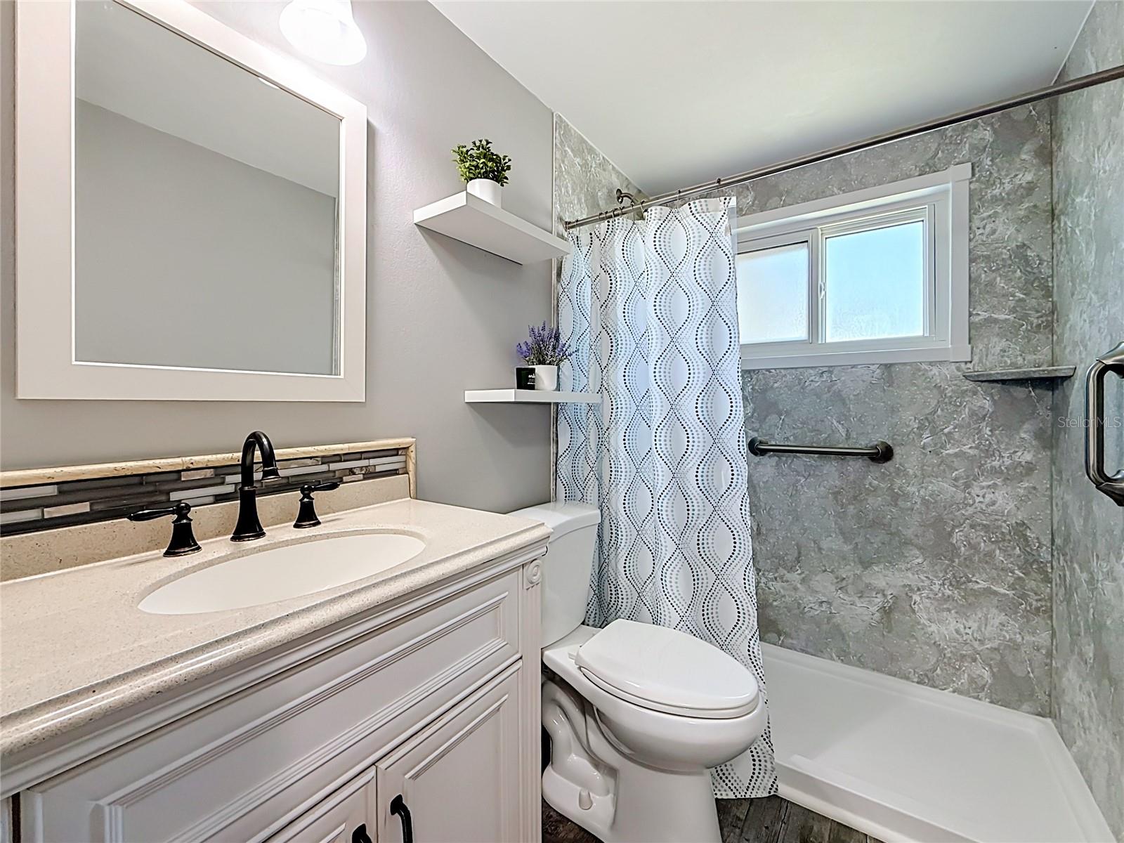 Remodeled Bathroom with new hurricane impact rated window and custom barn door