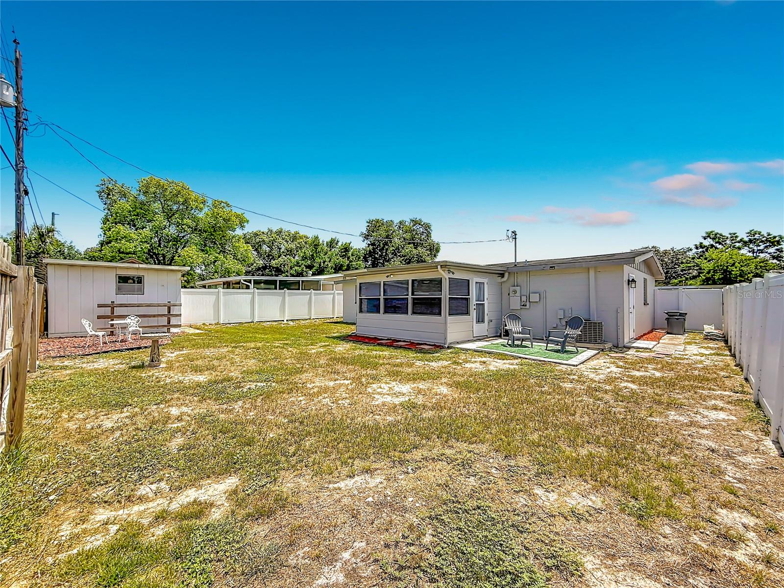 Large fenced in backyard with patio and shed with electric