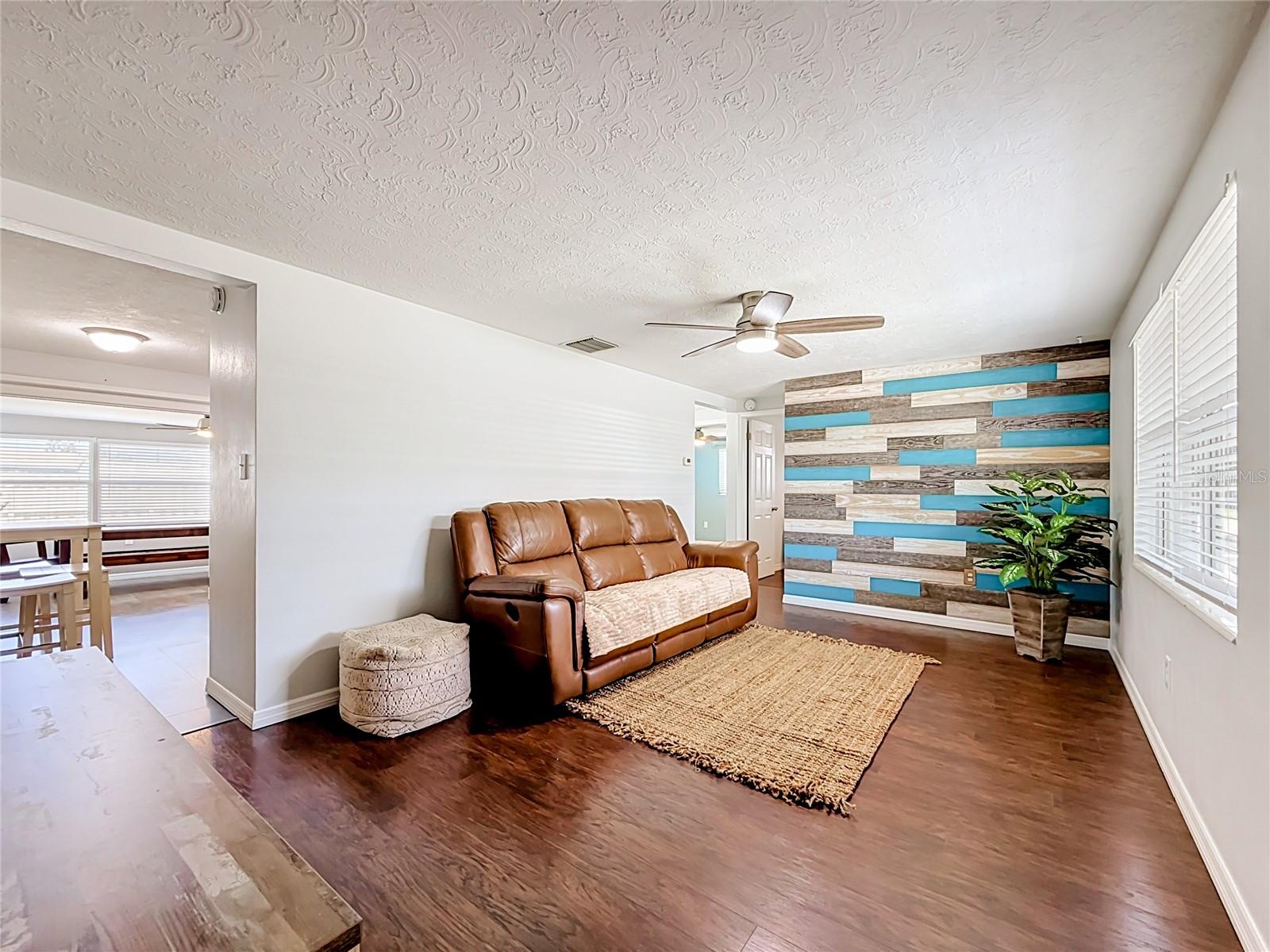 Living Room with custom wood panel accent wall and comes with a mounted 75 inch Samsung TV