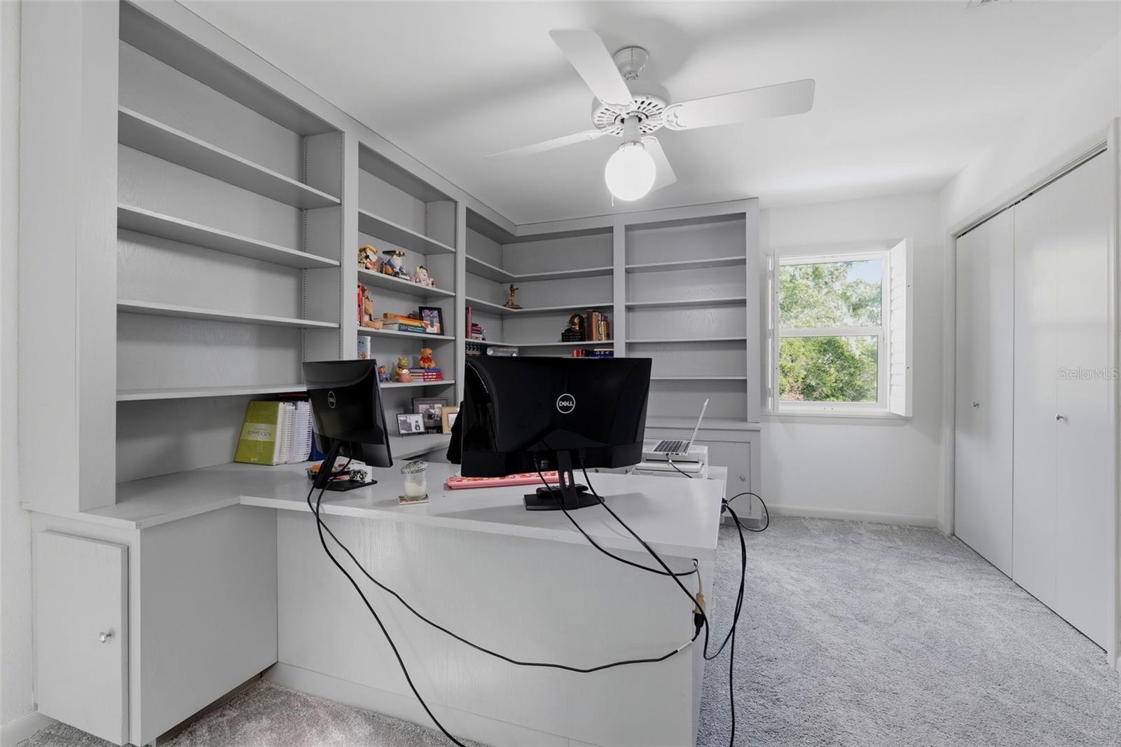 Upstairs bedroom currently being used as an office with built-in desk and cabinetry