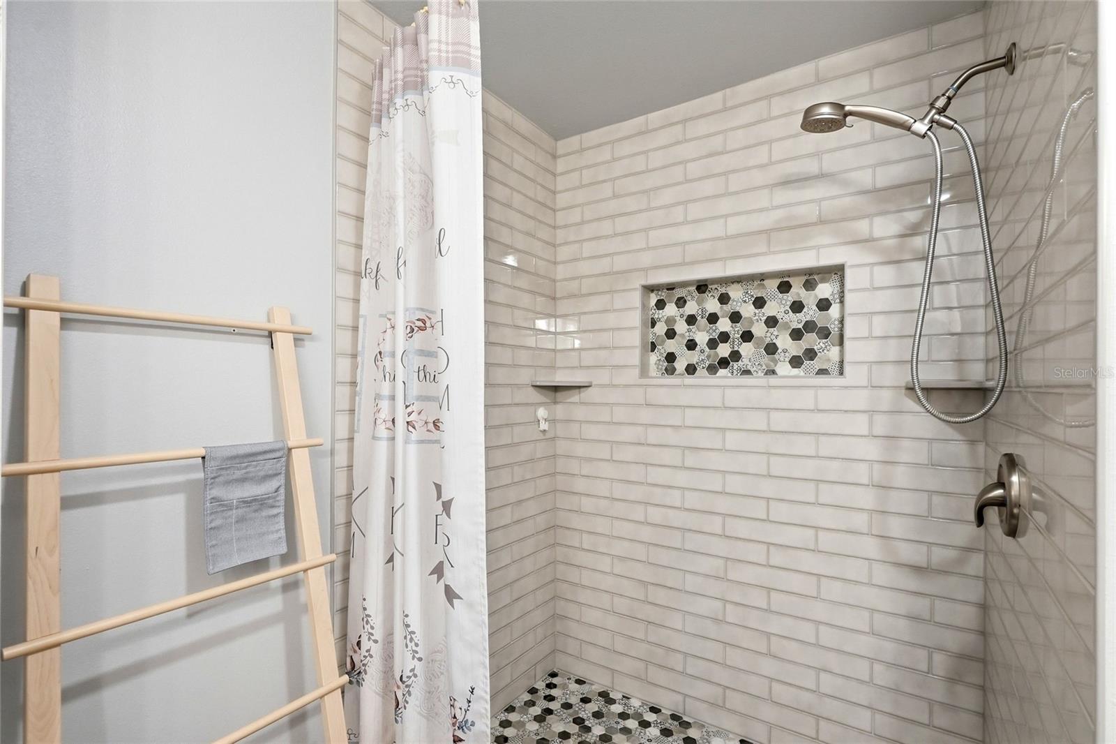 Beautifully remodeled primary bathroom featuring modern tile and quality finishes