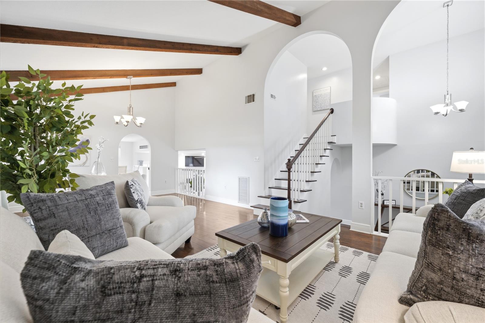 Formal living room with custom staircase leading to third floor bedrooms