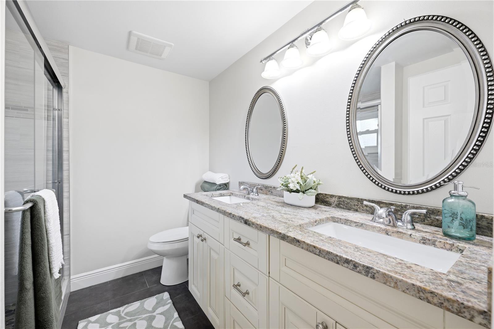 Nicely updated master bathroom with a large walk in shower and granite counters