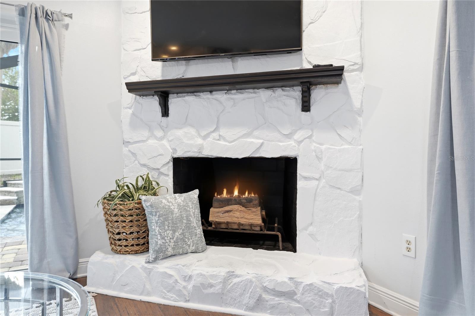 Stone mantle and wood burning fireplace