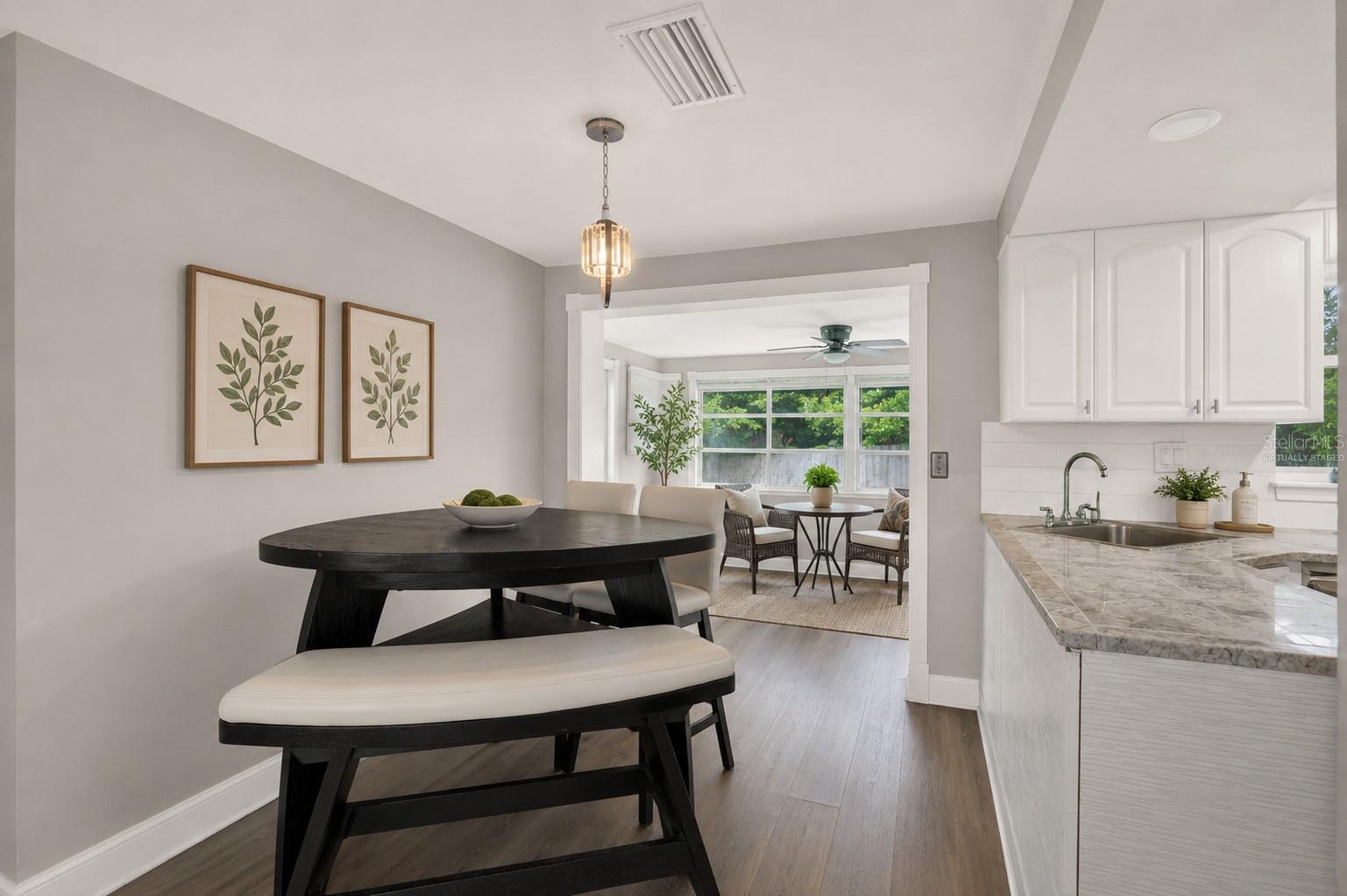 Dining space with view of sunroom/virtually staged