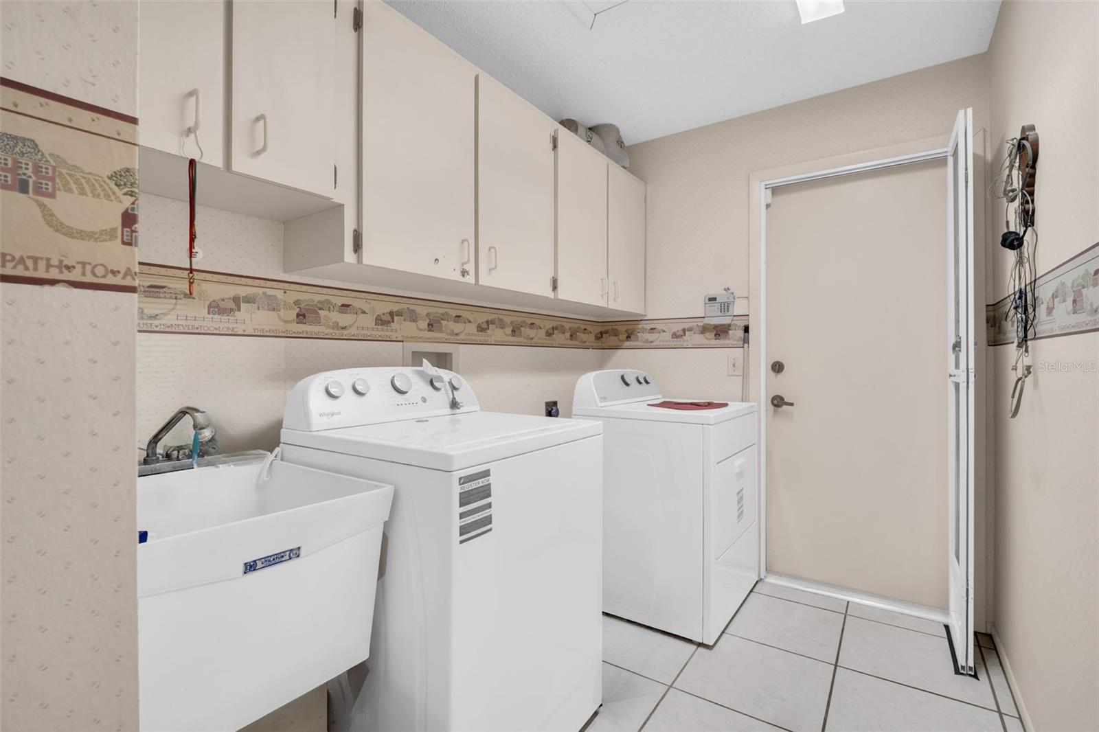 Indoor laundry with utility sink leading to the 2-car garage~