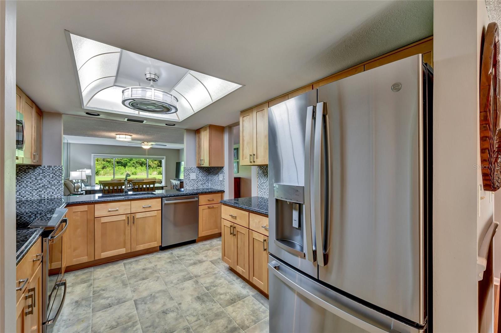 Kitchen has granite countertops and tile back splash.