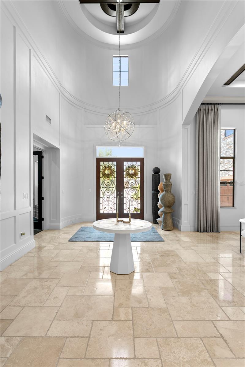 Rich travertine flooring, exposed beams, and custom millwork.