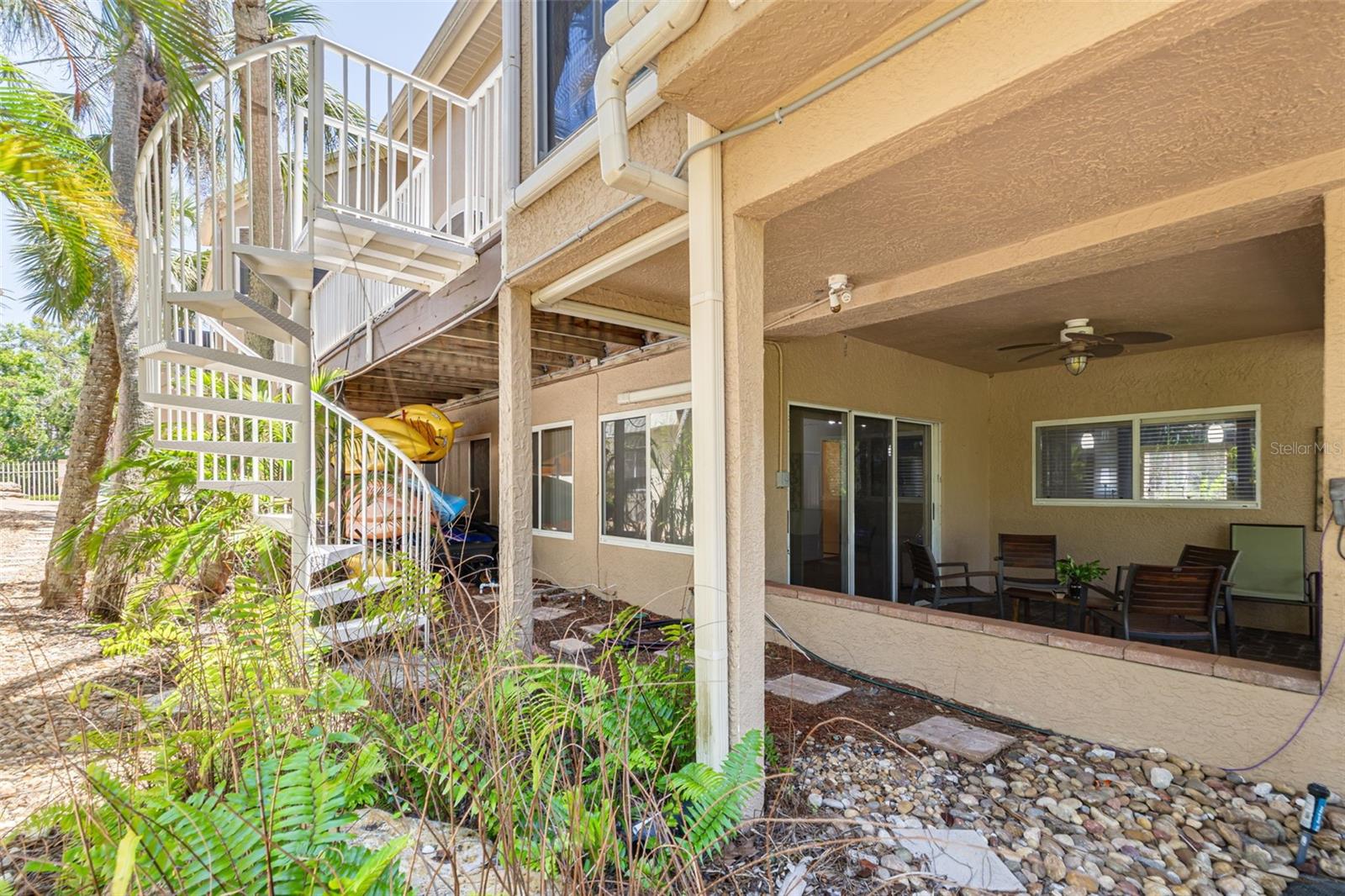 Spiral stairs from elevated deck to lower level patio