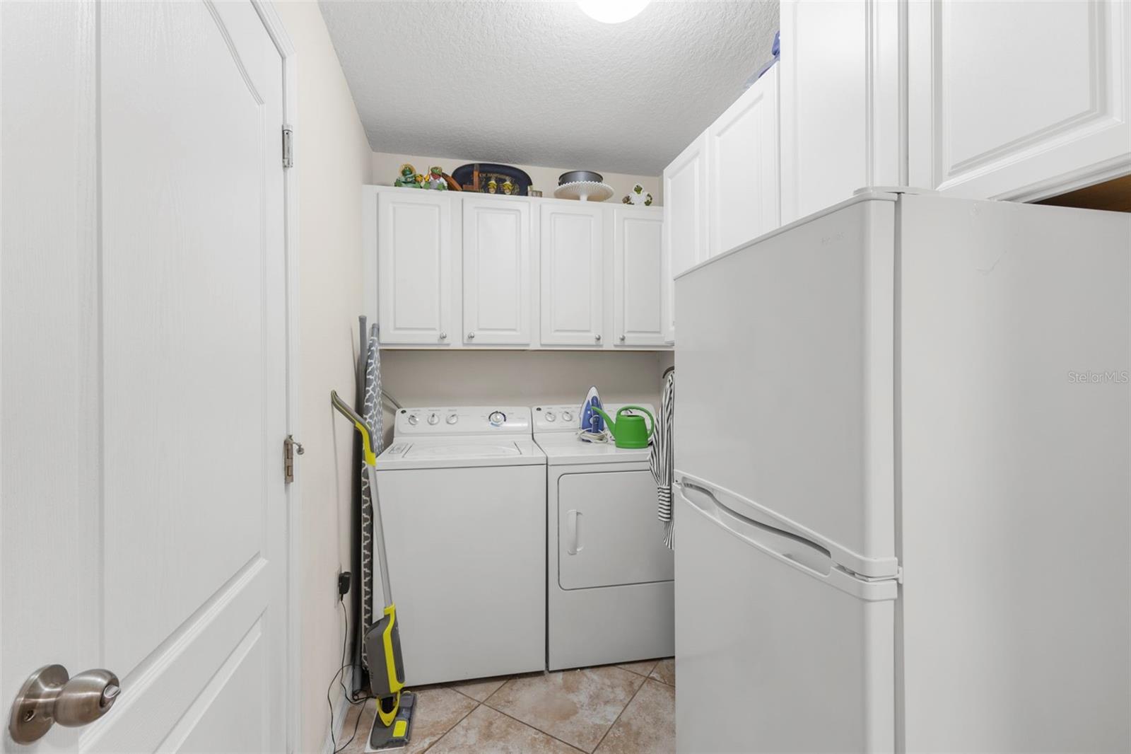 Laundry room with bonus refrigerator/freezer and cabinets for storage