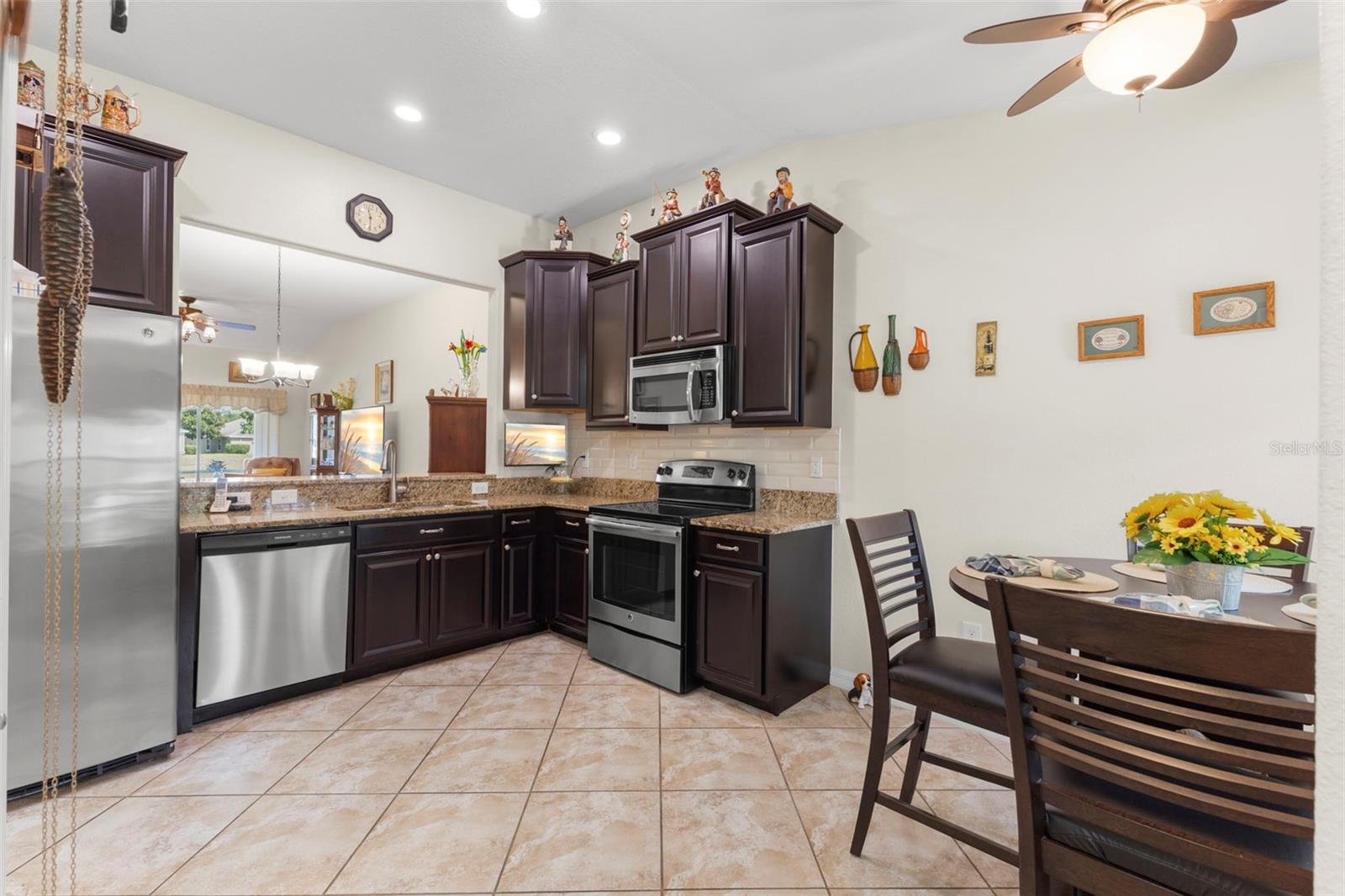Kitchen with dark wood cabinetry, Stainless Steel appliances and granite counters