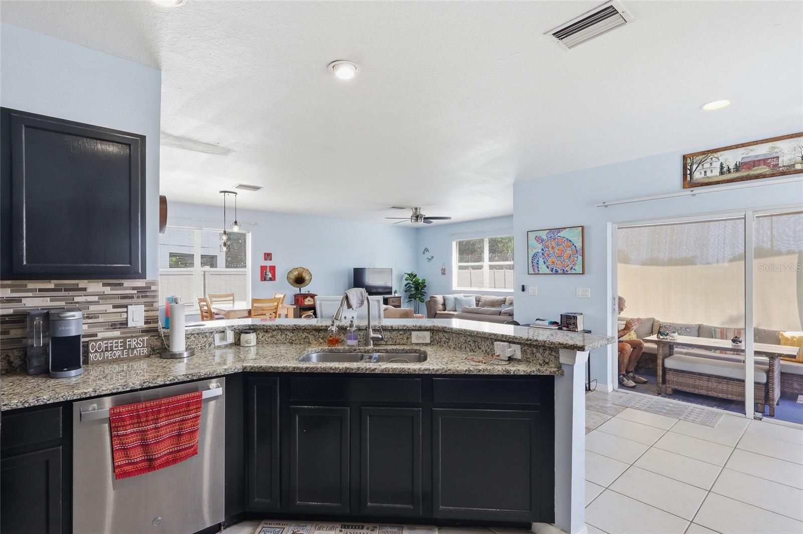 Open-concept kitchen with granite countertops and espresso cabinets