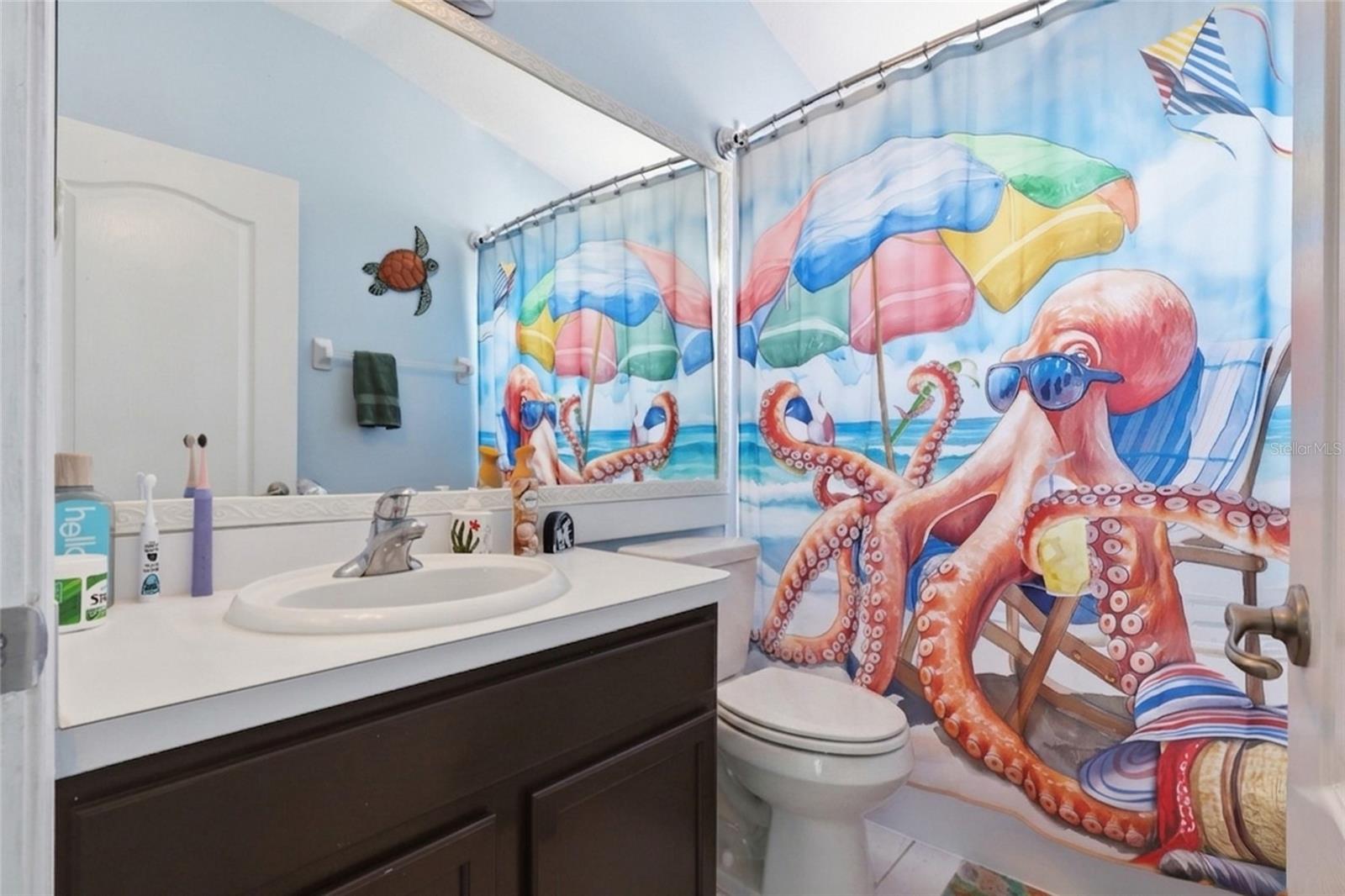 Coastal bathroom with ocean-themed decor and white vanity