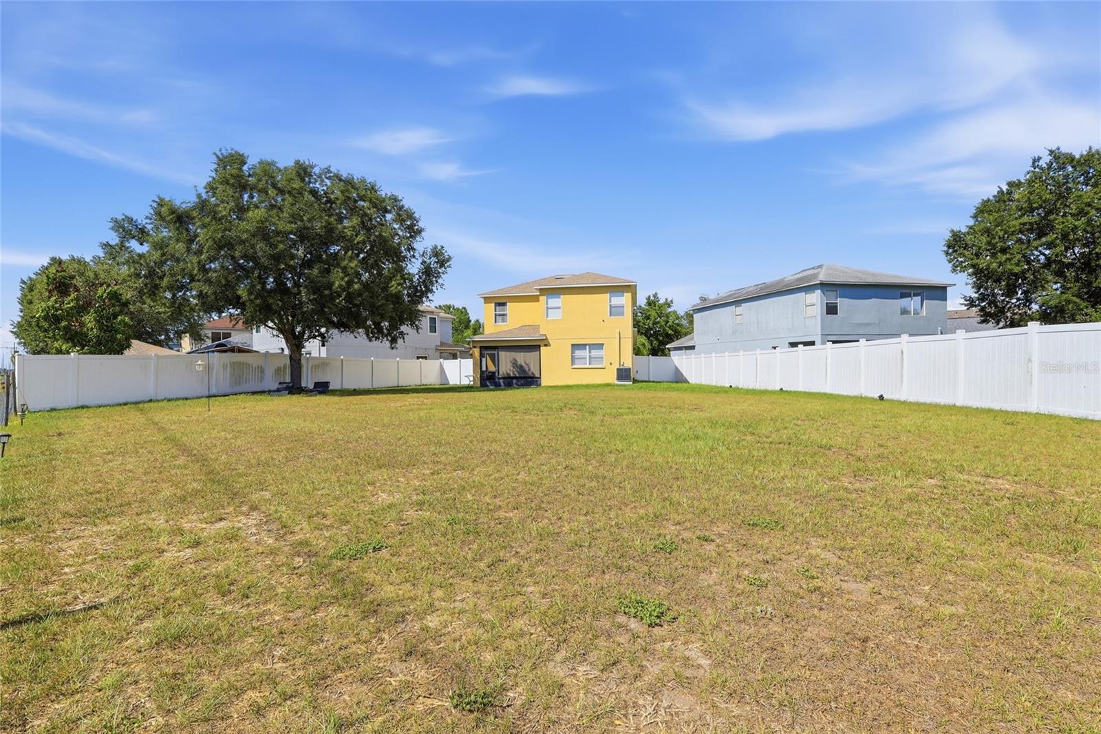 Oversized fully fenced backyard with mature oak tree