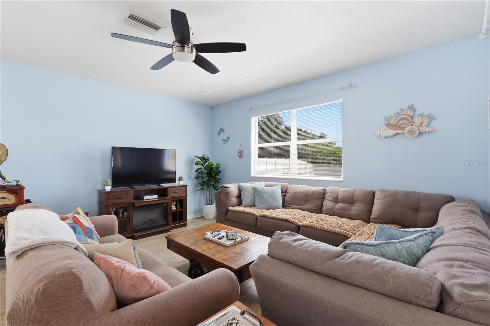 Spacious coastal living room with large sectional and ceiling fan