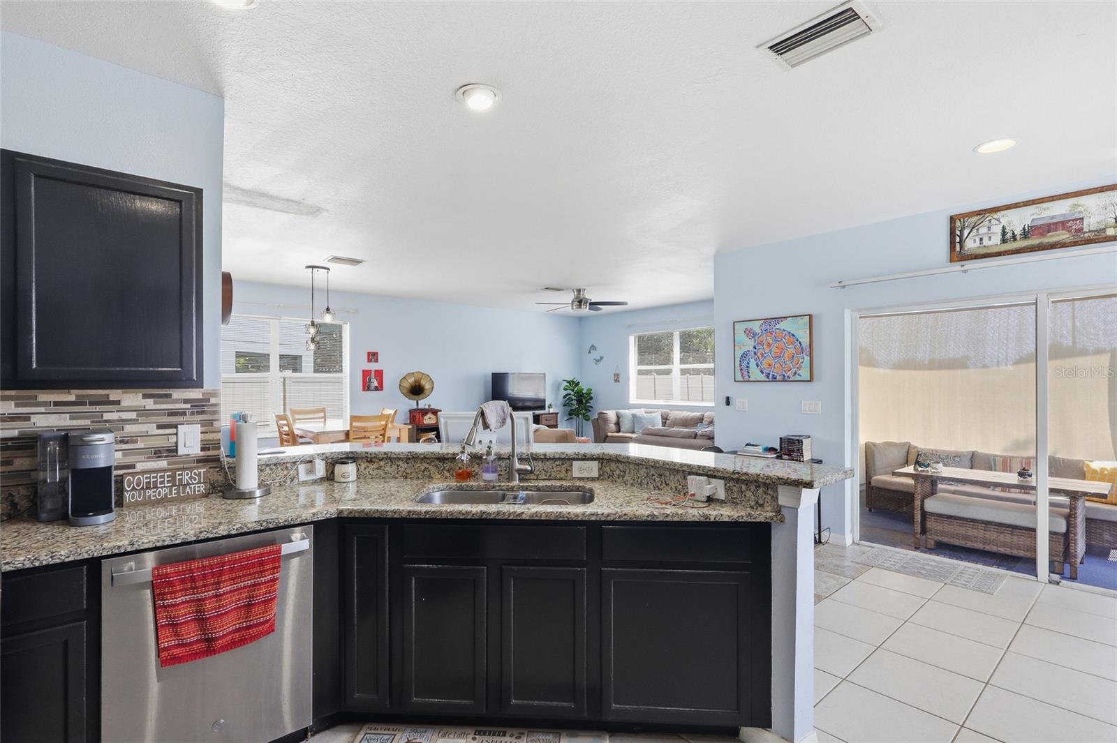 Kitchen island with granite counters, double sink and stainless appliances
