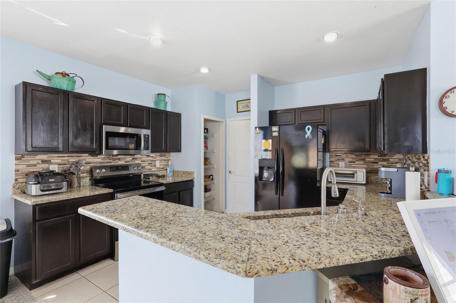 Full kitchen with granite counters, tile backsplash and pantry