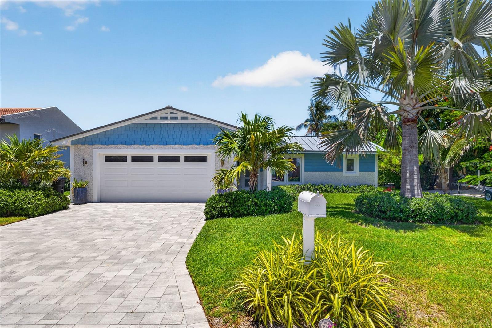 Professional landscaping, paver drive, and a stunning lawn.