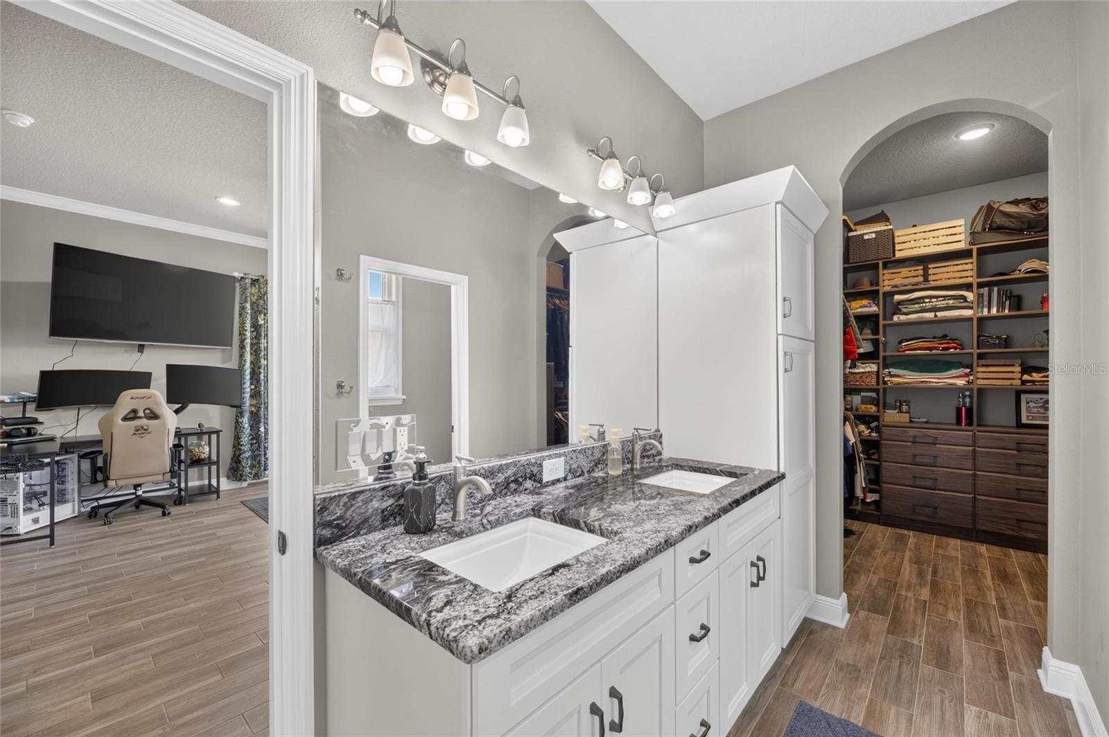 The primary bathroom leads to a large walk-in closet with built-ins...