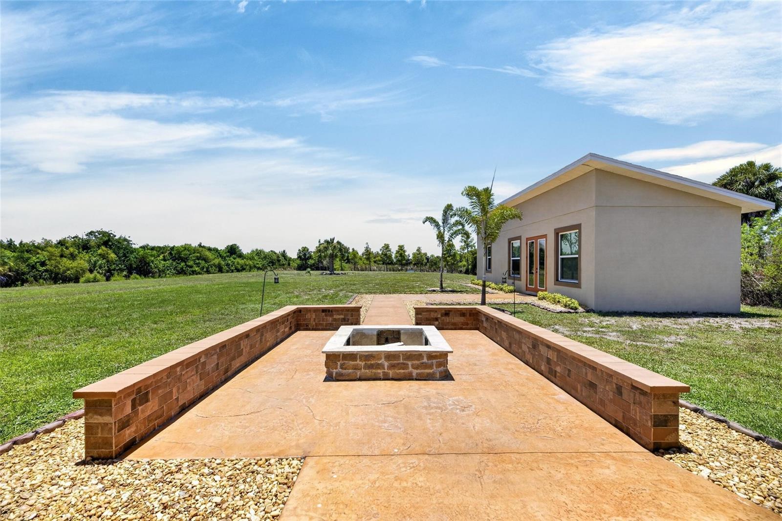 Behind the main house is this fire pit patio lounge with brick wall seating.