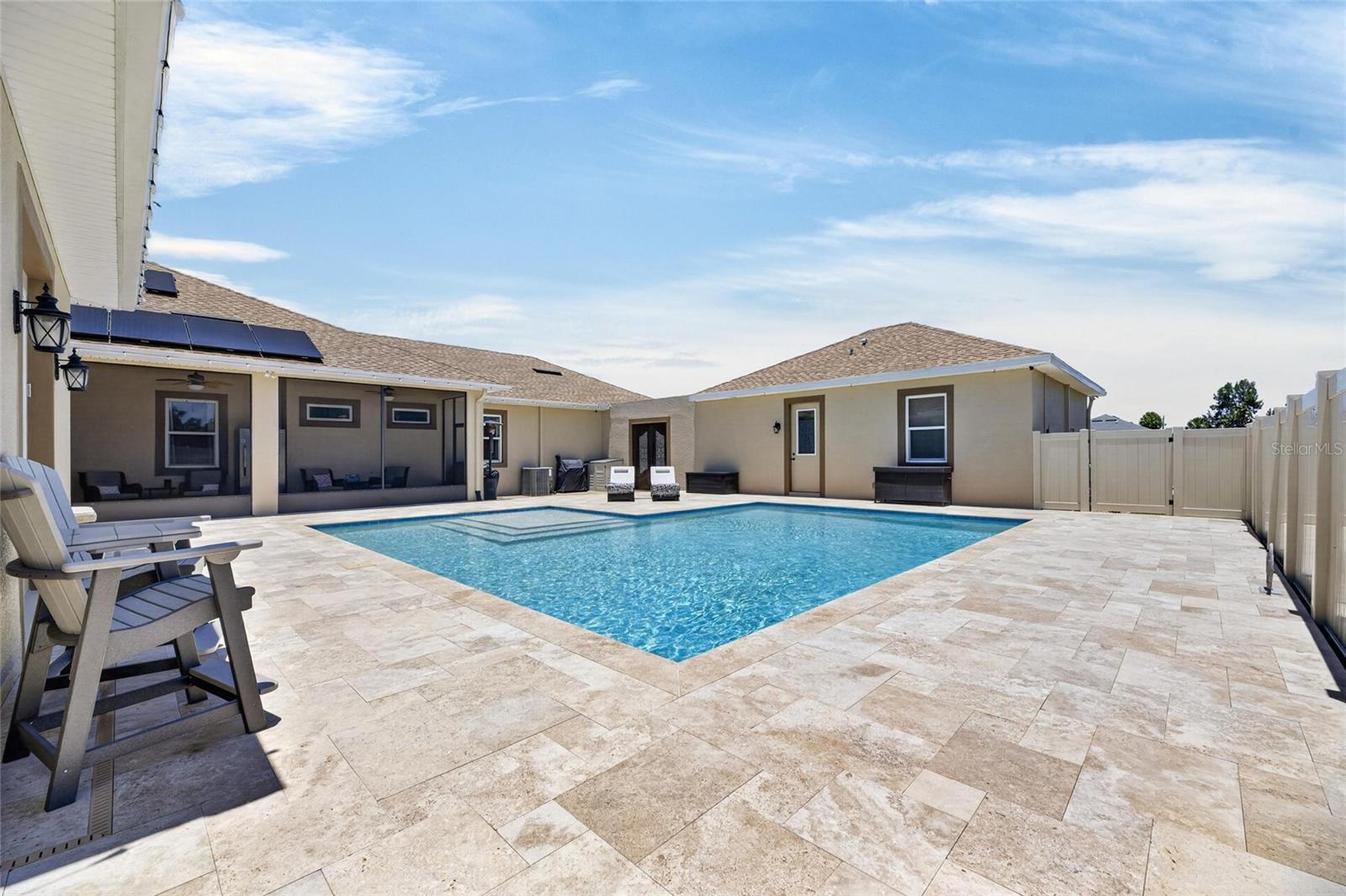 featuring a beautiful pool in a travertine deck.