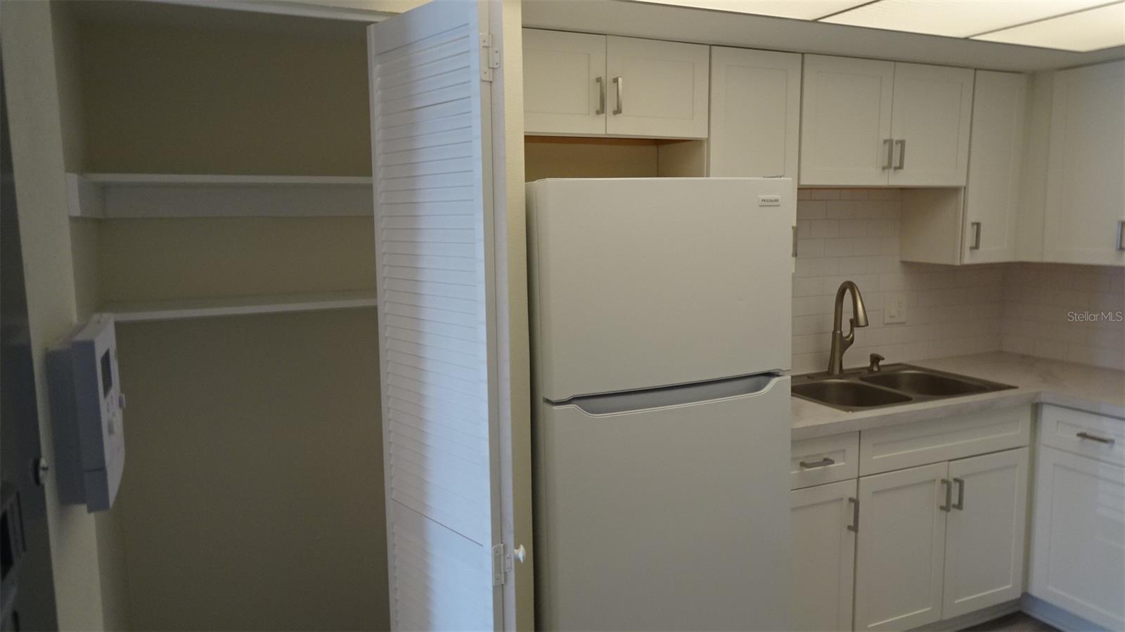 Pantry next to refrigerator