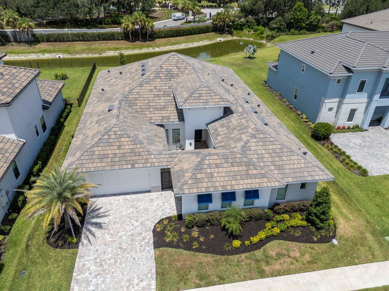 Elevated View of Front of Home - River's Edge Community - Tile Roof - Pavered Driveway