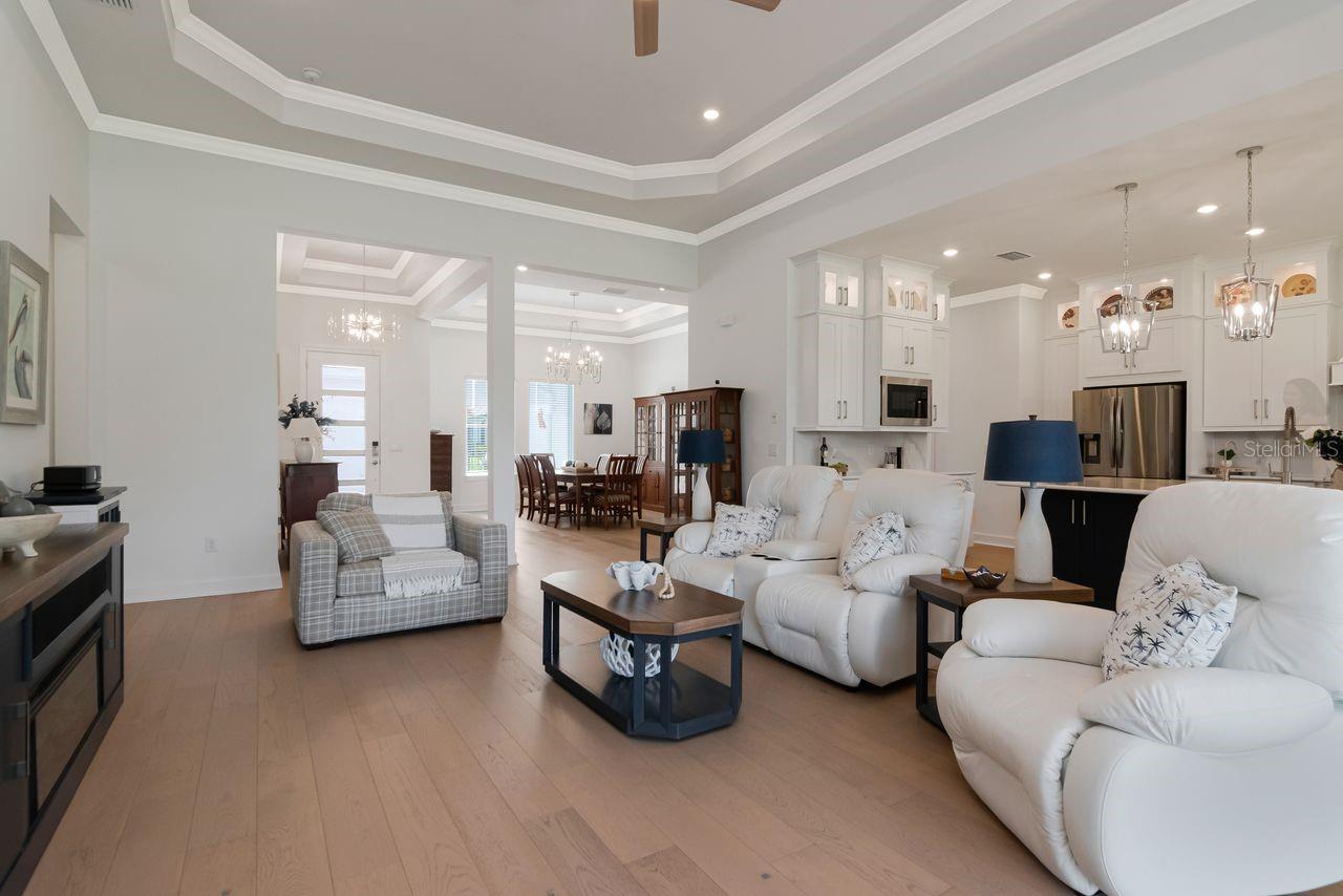 Living Room with Tray Ceilings with Crown Molding - Engineered Hardwood Floors - Upgraded Ceiling Fan - Floor Electrical Outlet