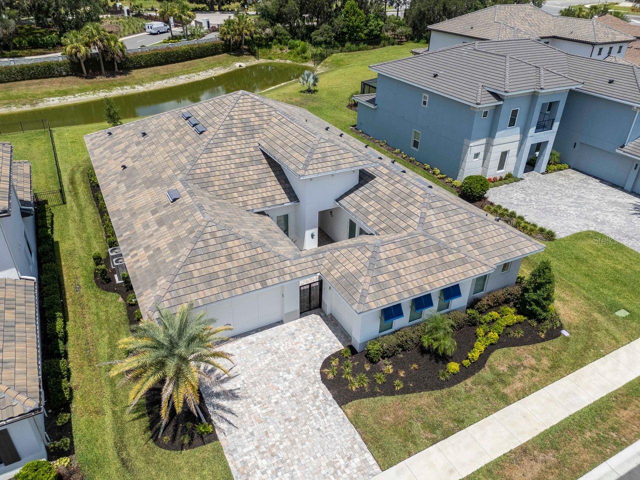 Aerial View of Home - Oversized Lot - Paver Driveway - Tile Roof - Courtyard Entrance with Gate - Premium Water Lot - Landscaped